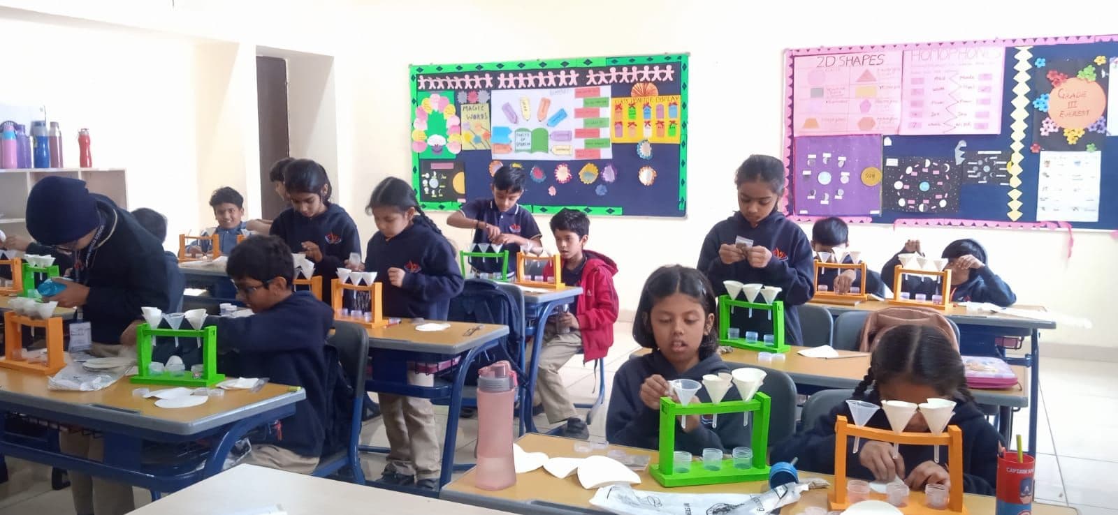 A classroom of students working at their desks with colourful boards behind